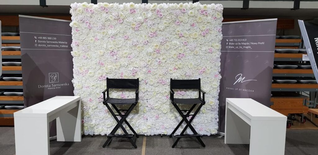 ścianka z kwiatów za stołem pary młodej